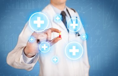 Haçlı bir hap gösteren bir doktor.