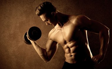 Kas formundaki vücut geliştirici sporcu ağırlık kaldırıyor 