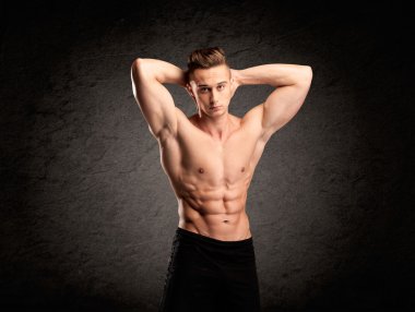 Seksi halterci adam kaslarını gösteriyor.