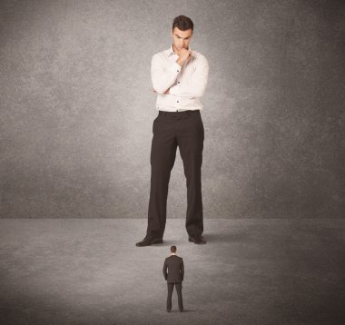 Büyük iş adamı küçük işçilere bakıyor.