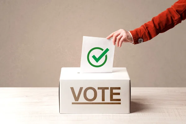 Fechar a mão masculina colocando voto em uma urna — Fotografia de Stock