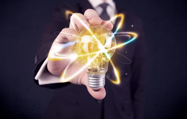 Businessman holding a colorful light bulb — Stock Photo, Image