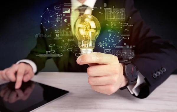 Businessman holding glowing glass light bulb — Stock Photo, Image