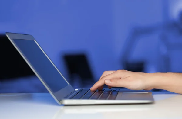 Empresário pressionando computador portátil moderno em backgrou colorido — Fotografia de Stock