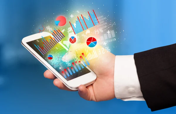 Business man holding smartphone with chart symbols — Stock Photo, Image