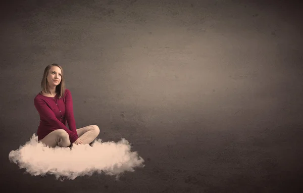 Woman sitting on a cloud with plain bakcground — Stock Photo, Image