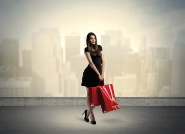 Alışveriş torbalarıyla duran şehir kadını.