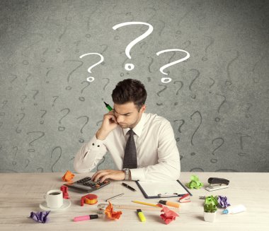 İş adamı soru işaretiyle masada.