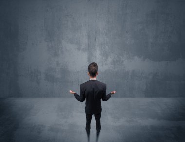 Şehir duvarının önünde duran iş adamı