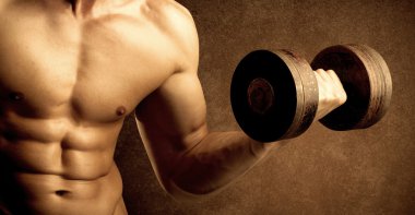 Kas formundaki vücut geliştirici sporcu ağırlık kaldırıyor 