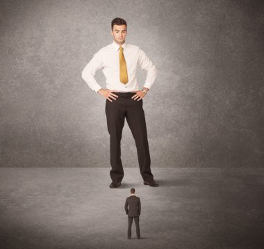 Büyük iş adamı küçük işçilere bakıyor.