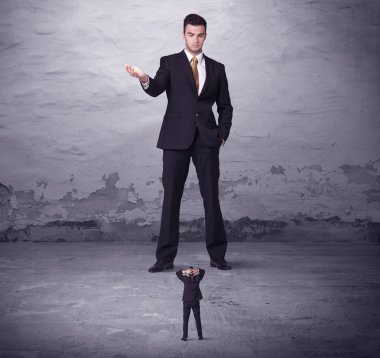 Kızgın büyük müdür küçük iş adamına bakıyor.