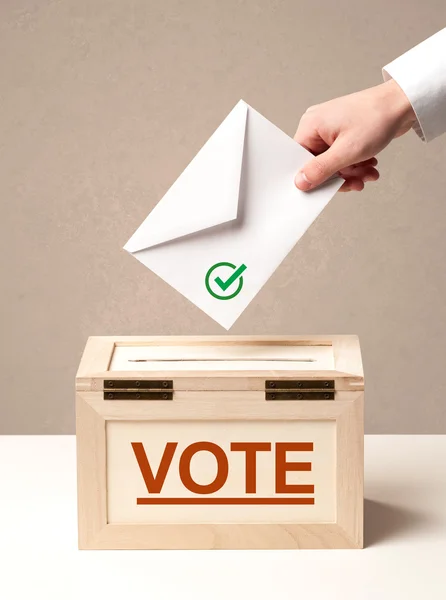 Fechar a mão masculina colocando voto em uma urna — Fotografia de Stock