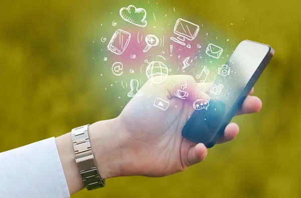 Hand holding smartphone with media icons — Stock Photo, Image