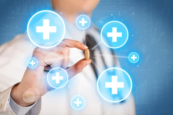 A doctor showing a pill with crosses — Stock Photo, Image