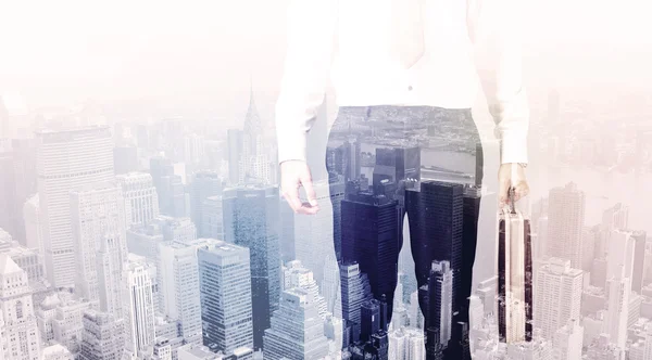 Business man standing on roof with city in the background — Stock Photo, Image