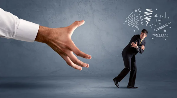 Stressful businessman running from a big hand — Stock Photo, Image