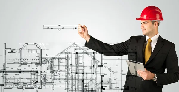 Genç bir mimar ev planı çiziyor.