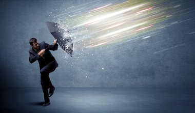 Şemsiye konseptiyle ışık demetlerini savunan iş adamı