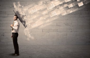 İş adamı ile şemsiye kağıtları rüzgara karşı koruma