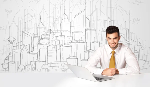 Zakenman zittend aan de witte tafel met handgetekende gebouwen — Stockfoto