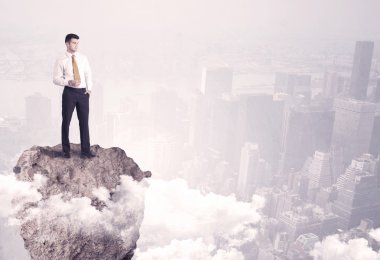 Kayanın üzerinde duran kazanan iş kişi