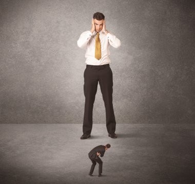 Büyük iş adamı küçük işçilere bakıyor.