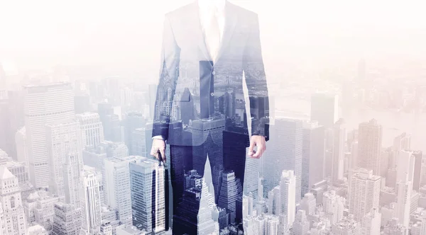 Business man standing on roof with city in the background — Stock Photo, Image