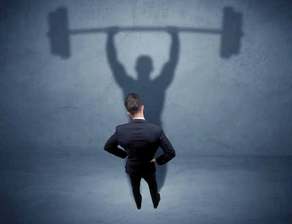 Businessman with weight lifting shadow — Stock Photo, Image