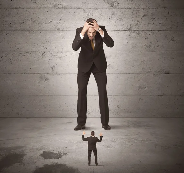 Enorme cara de negócios olhando para pequeno colega de trabalho — Fotografia de Stock