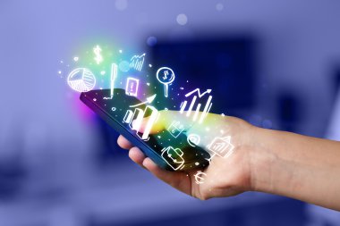 Finans ve pazar simgelerine ve sembollerine sahip akıllı telefon