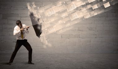 İş adamı ile şemsiye kağıtları rüzgara karşı koruma