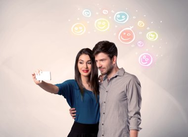 Mutlu çift gülen yüzle selfie çekiyor.