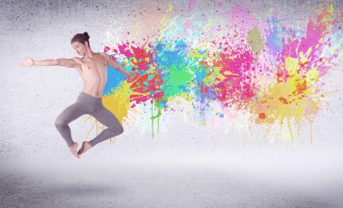 Renkli boyalarla zıplayan modern sokak dansçısı.