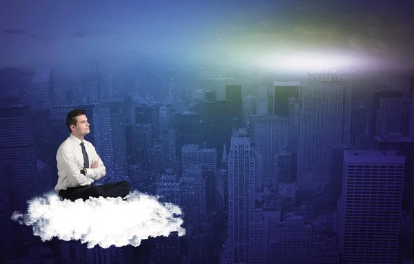 Man sitting on a cloud above the city — Stock Photo, Image