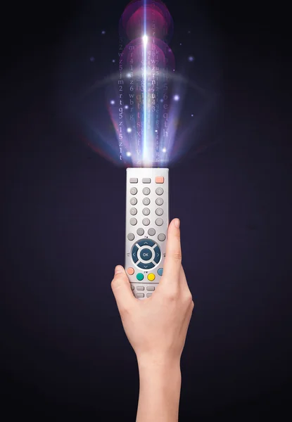 Hand with remote control and shining numbers — Stock Photo, Image