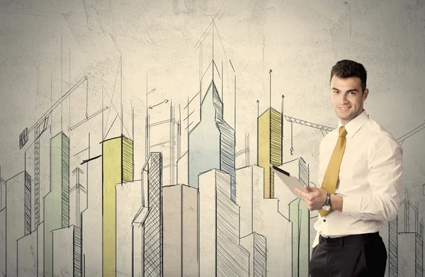 Businessman standing with drawn cityscape — Stock Photo, Image