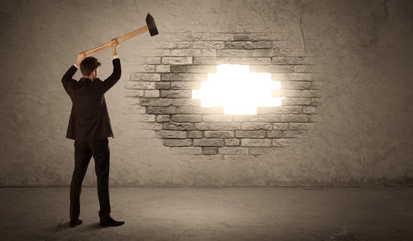 Homem de negócios batendo parede de tijolo com martelo e abrir um buraco — Fotografia de Stock