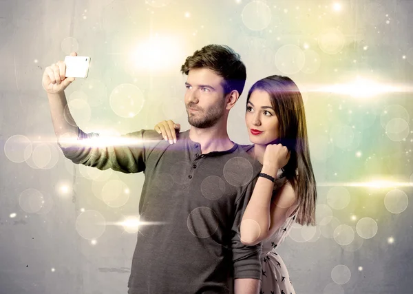 Smiling couple taking selfie in glitter light — Stock Photo, Image