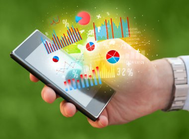 İşadamı elinde grafik sembollü akıllı telefon tutuyor.