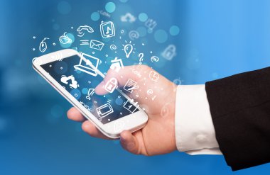 Medya simgeleri ve sembolleriyle el ele tutuşan akıllı telefon 