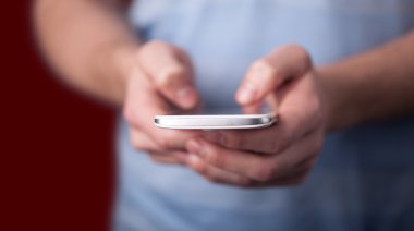 Elinde tutan smarthphone genç adam 