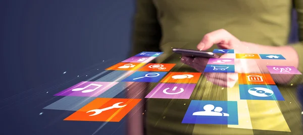 Женщина держит смартфон с красочными иконками приложения — стоковое фото