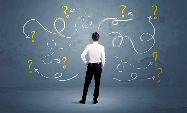 Unsure businessman with question marks — Stock Photo, Image