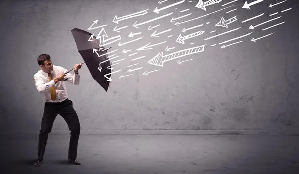 Affärsman stående med paraply och ritade pilar slå honom — Stockfoto