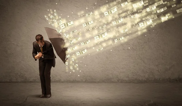 Uomo d'affari in possesso di ombrello contro il concetto di pioggia dollaro — Foto Stock