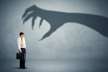 İş kişi büyük canavar pençe gölge kavramı korkuyor