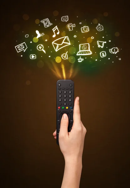 Hand with remote control and social media icons — Stock Photo, Image