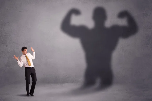 Uomo d'affari guardando il proprio concetto di ombra forte in forma — Foto Stock