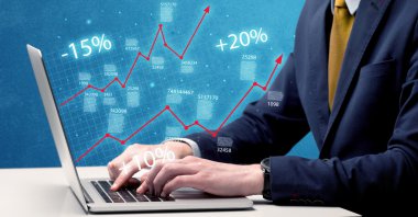 Satıcı dizüstü bilgisayarla grafikle çalışıyor.